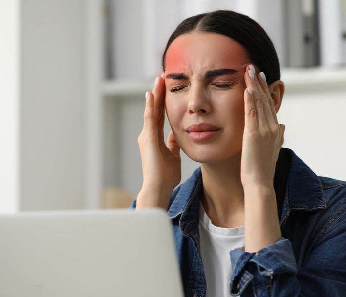 Woman experiencing headaches at work